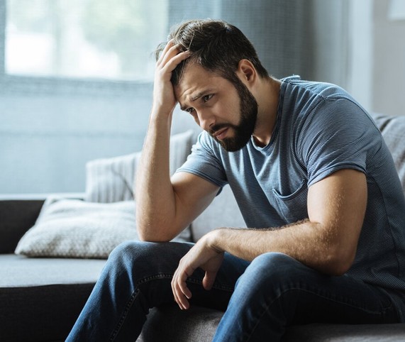 depressed man sitting on bed side